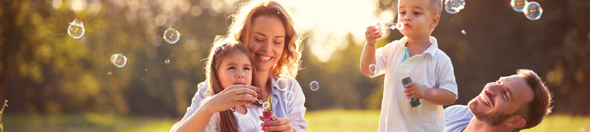 A family having fun with bubbles in a park