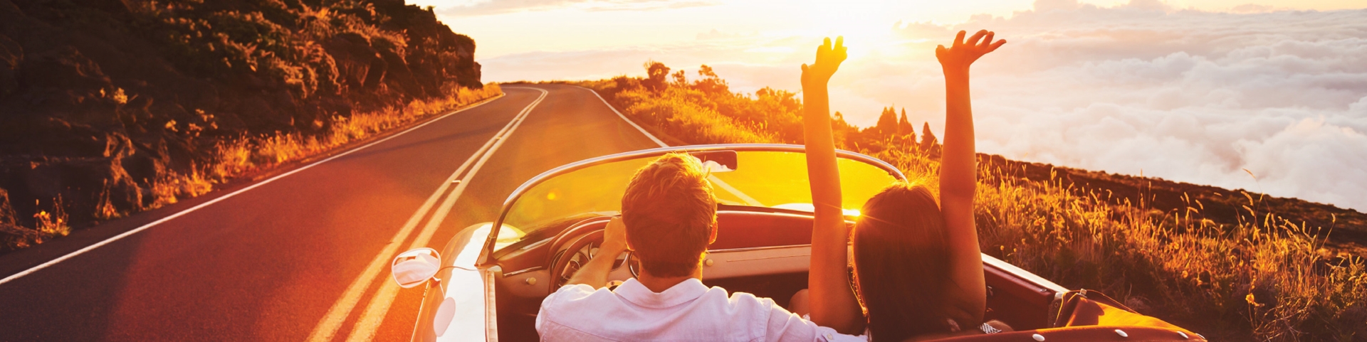 Couple driving through a highway in the sunset