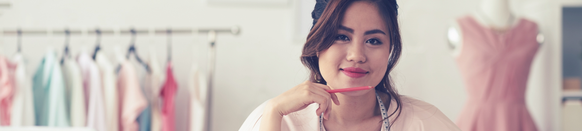 A women in a clothing designer office smiling at the camera