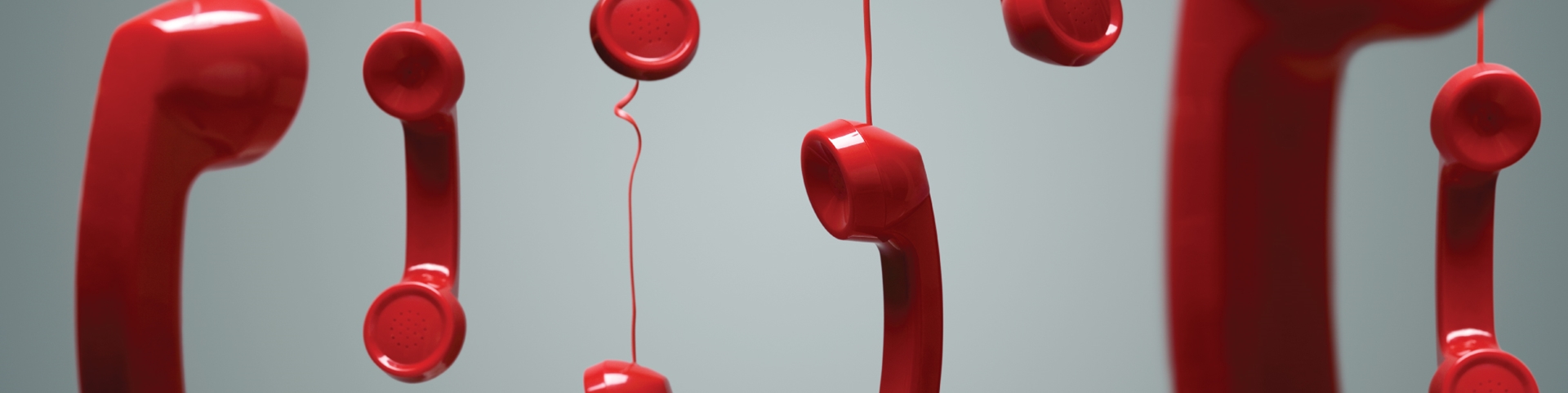 Red phones hanging on their wires