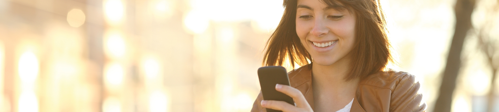 A woman looking at her phone smiling